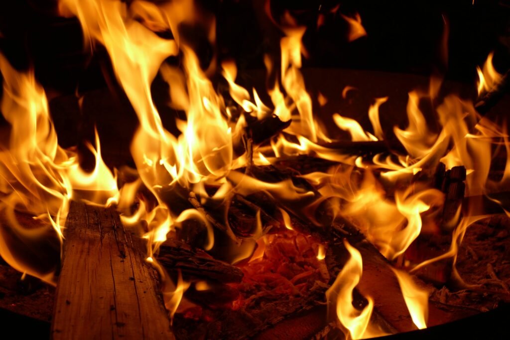 A mesmerizing close-up of a bonfire with vibrant flames and burning wood.